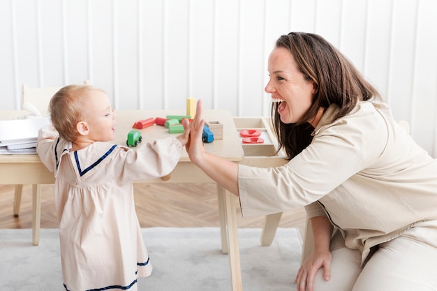 Free photo baby making high five with her mother