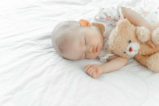 Baby sleeping with a teddy bear