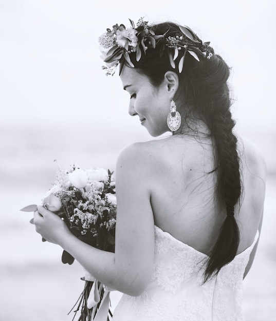 Back of a bride holding a bouquet of flowers