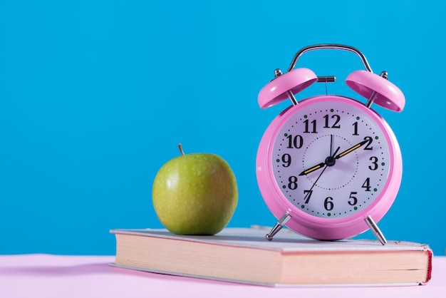 Free photo back to school background with books,apple and alarm clock