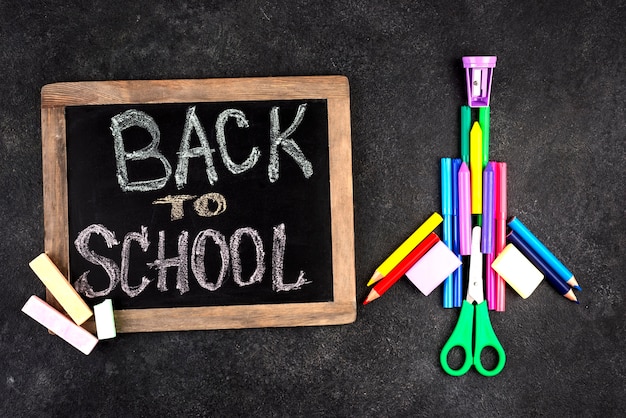 Back to school background with school supplies and chalkboard