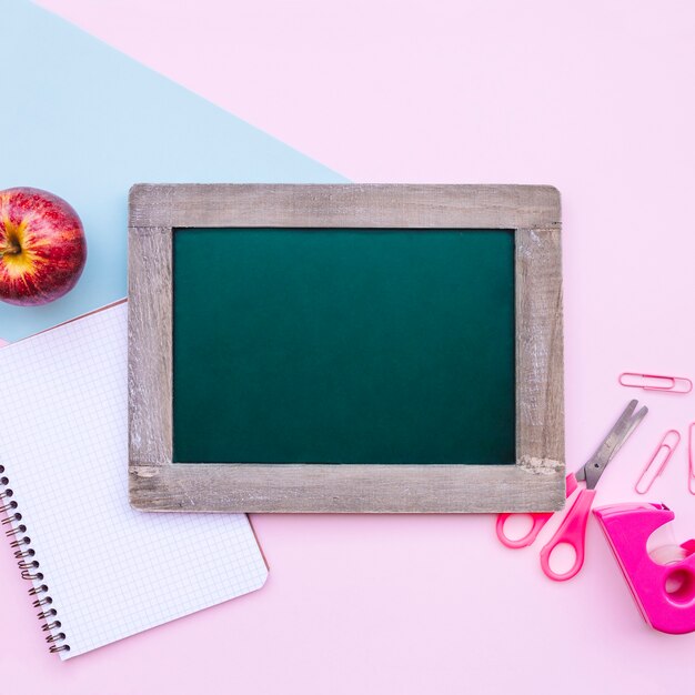 back to school composition with green slate for mock up on light blue and pink background