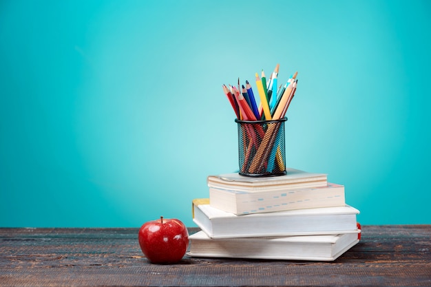 Free photo back to school concept. books, colored pencils and apple