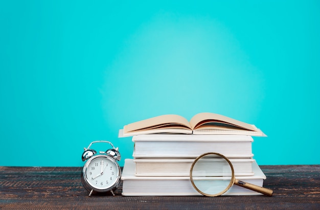 Free Photo back to school concept. books, colored pencils and clock