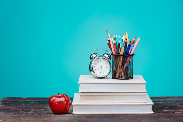 Free photo back to school concept. books, colored pencils and clock