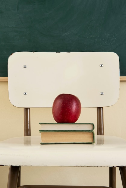 Free photo back to school concept with apple on chair