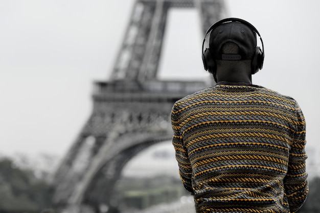 Back view of an African-American man in headphones with Eiffel tower