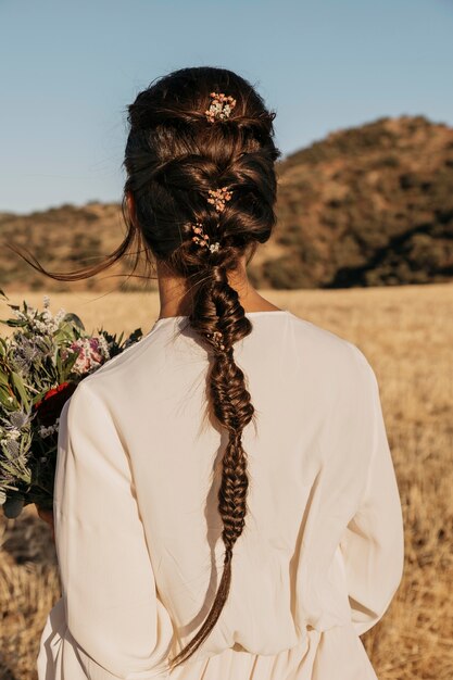 Back view bride holding flowers bouquet