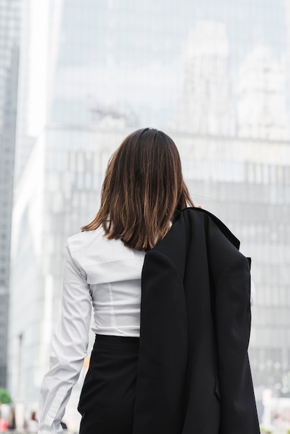 Back view business woman holding a jacket