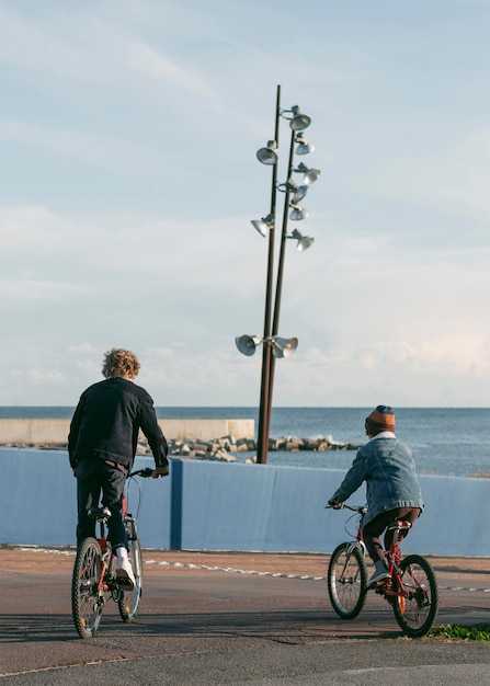 Back view of child friends outdoors on bikes