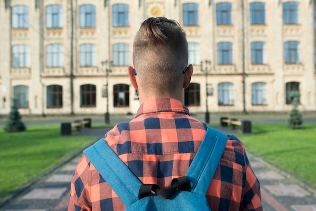 Back view  close up teenage boy  walking to highschool