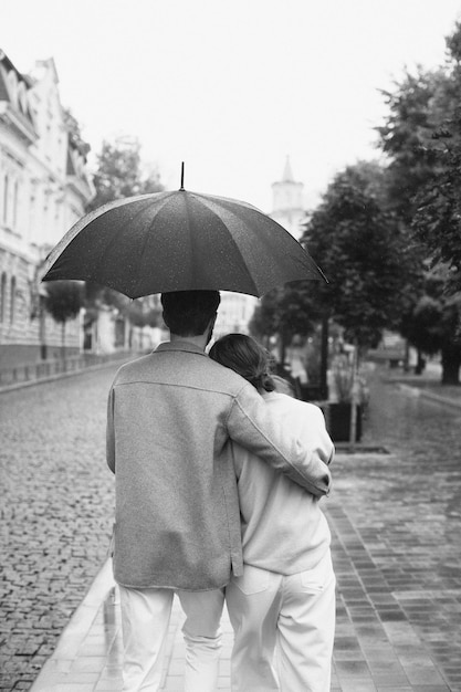 Free photo back view couple walking in rain