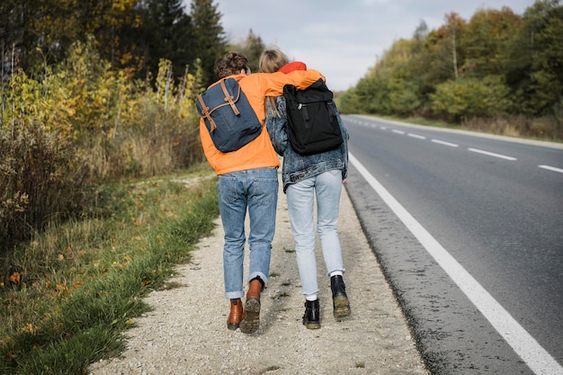 Free Photo back view of couple walking on the side of the road together