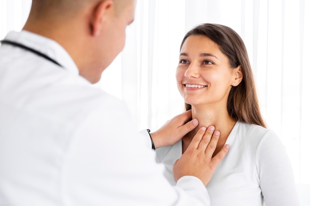 Free photo back view doctor examining woman neck