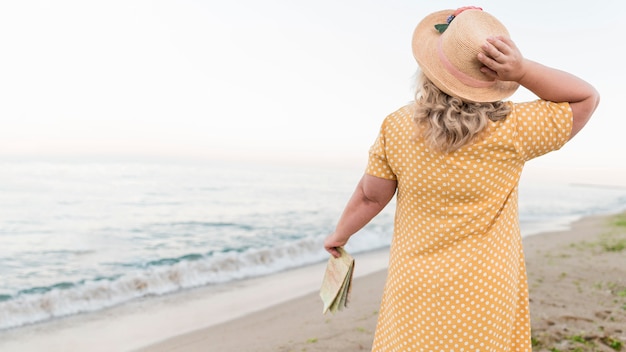 Back view of elder tourist woman at the beach