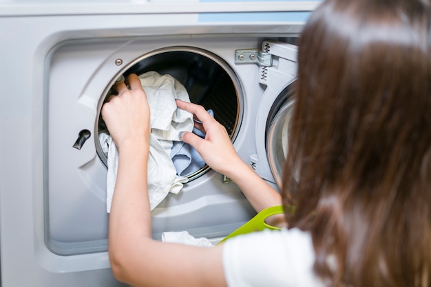 Free photo back view of female doing laundry