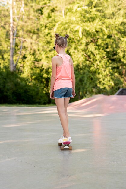 Back view of girl riding skateboard