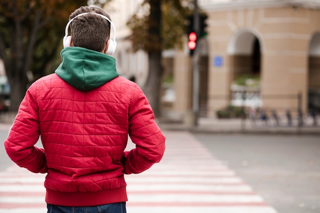 Back view guy with headphones outdoors