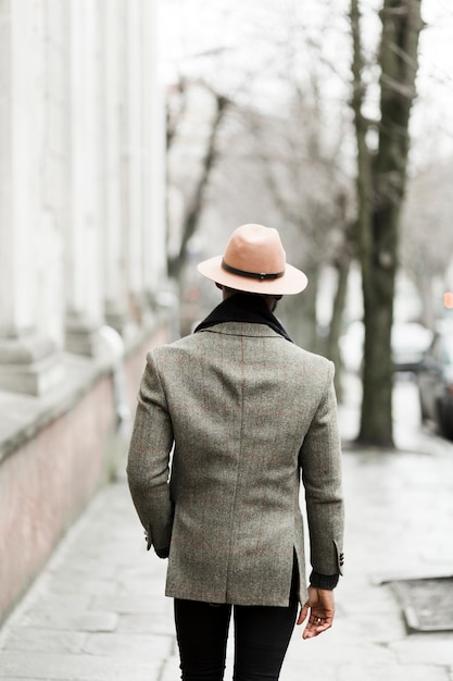 Back view handsome man in grey jacket walking