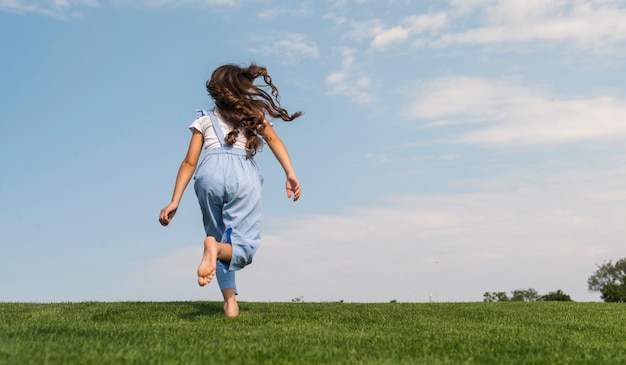 Back view little girl running barefoot