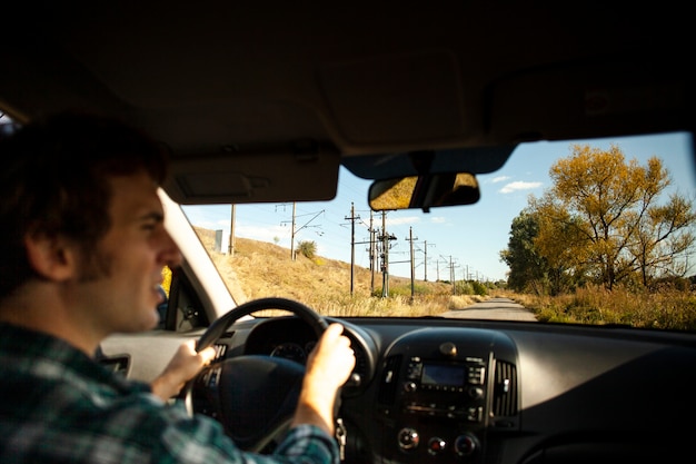 Back view male driver holding the wheel