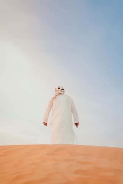 Free Photo back view of a male on sandy dessert