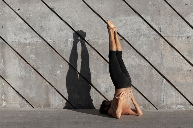 Free Photo back view of man doing yoga outdoors