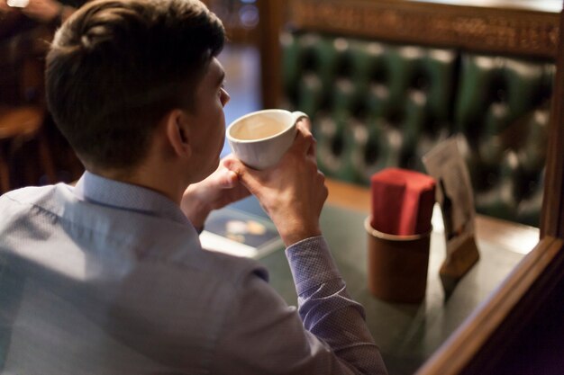 Back view man drinking coffee in restaurant