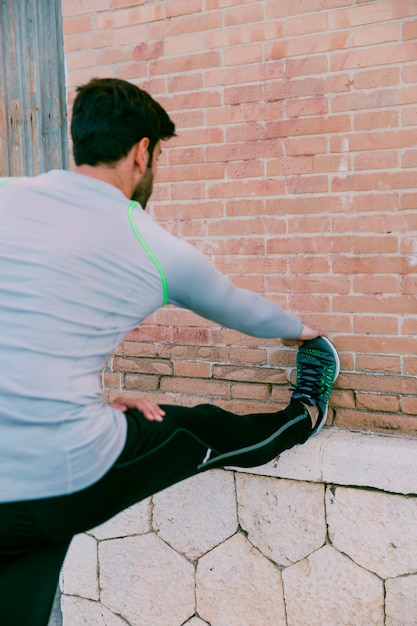 Back view man exercising near wall