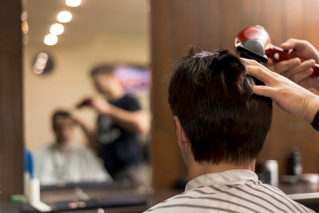 Back view man getting a haircut