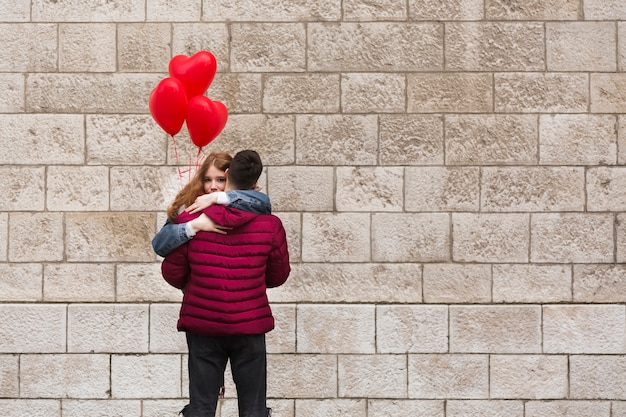 Free photo back view man hugging girlfriend