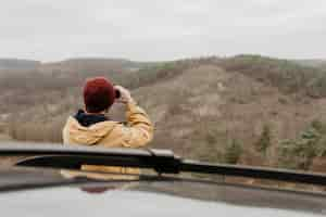 Free photo back view man looking through binoculars