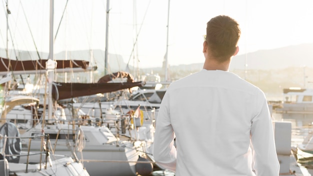 Free photo back view of man at the marina