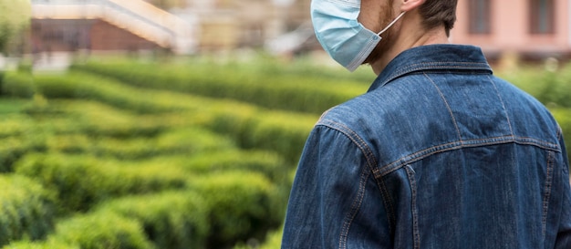 Free photo back view man with face mask looking away