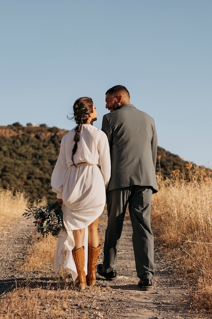 Free photo back view married couple holding hands