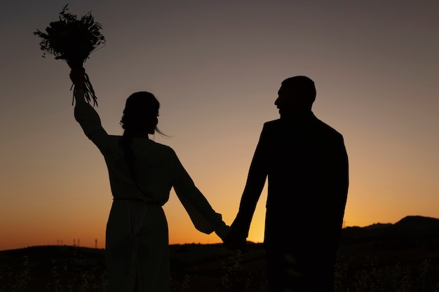 Back view married couple holding hands