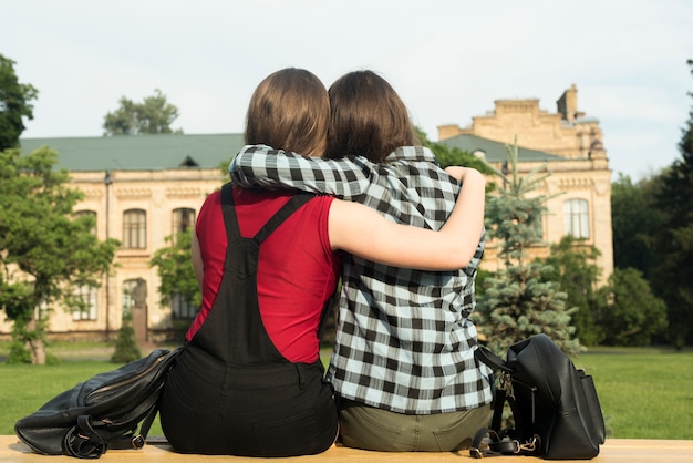 Free photo back view medium shot of two teenage girls hugging