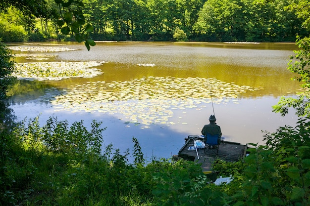 Free photo back view of a person coarse fishing at a lake in wiltshire, uk in the early morning