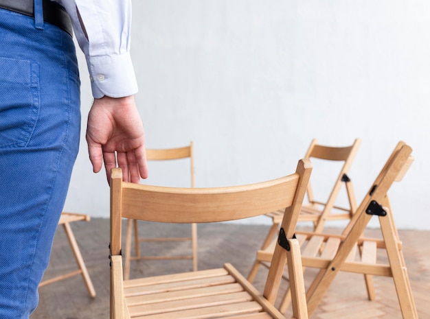 Free photo back view of person with empty chairs prepared for group therapy