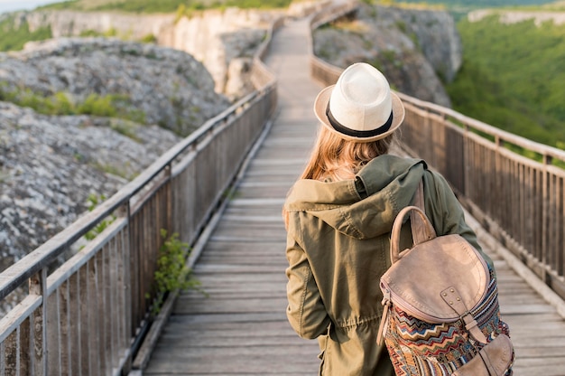 Free Photo back view stylish traveller with hat walking