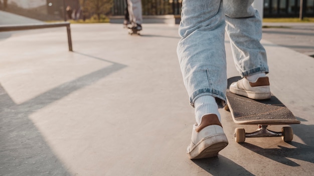 Back view of teenager with skateboard and copy space at the skatepark