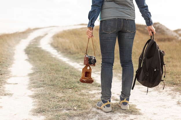 Back view traveler holding backpack