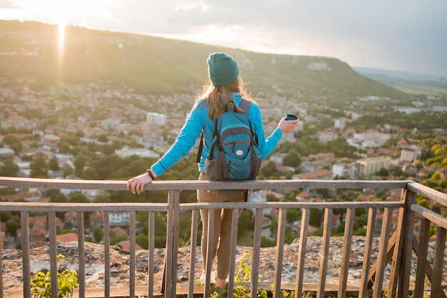 Back view traveller with beanie enjoying holiday