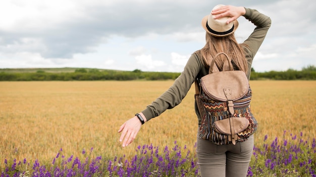 Free photo back view traveller with hat and backpack