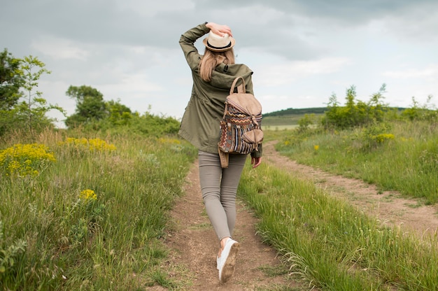 Free Photo back view traveller with hat walking outdoors