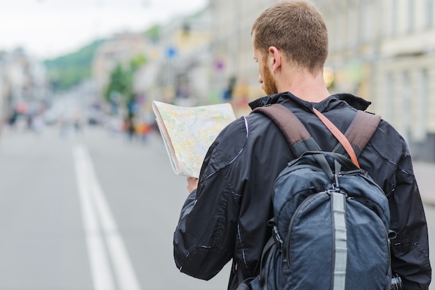 Free photo back view of traveller with map