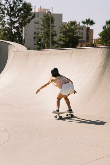 Back view of urban girl skating