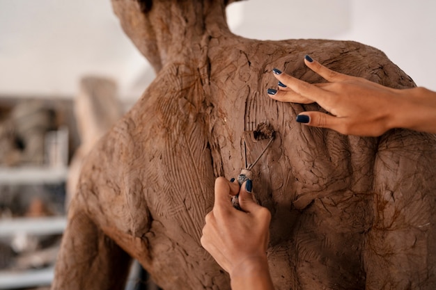 Free photo back view woman clay sculpting