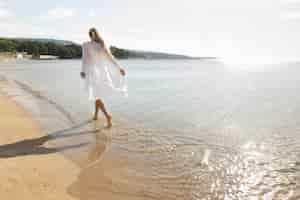 Free photo back view of woman enjoying the beach sands