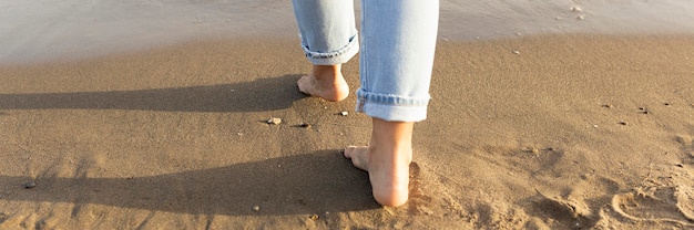 Back view of woman feet on sands